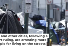 A person walks past a homeless encampment in the Skid Row community in Los Angeles in June 2024. Mario Tama/Getty Images